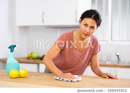 Woman washing kitchen table during cleanup Woman washing kitchen table during cleanup 109445932