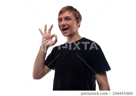 Confident teenager guy in a black T-shirt on a background with copy space 109445960