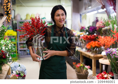 Store employee makes Christmas arrangement with flowers 109446001