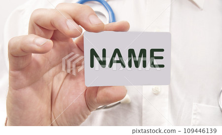 NAME word on the card in a man's hand on the background of a white shirt NAME word on the card in a man's hand on the background of a white shirt 109446139
