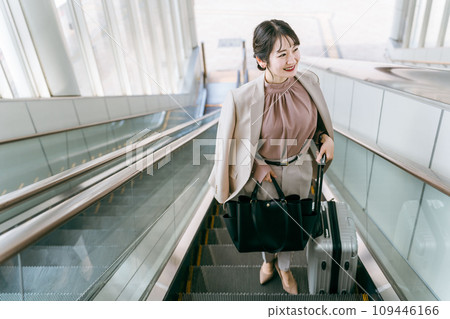 Business woman on a business trip climbing up the escalator at the airport/station (commuting/commuting) Business woman on a business trip climbing up the escalator at the airport/station (commuting/commuting) 109446166