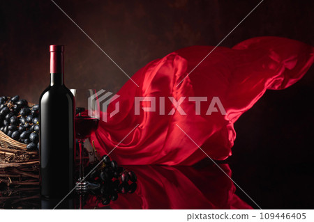 Red wine with grapes on a background of red flutters curtain. Red wine with grapes on a background of red flutters curtain. 109446405