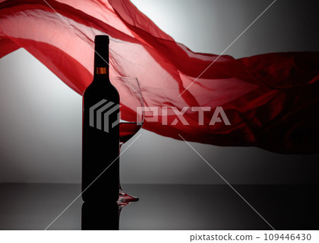 Bottle and glass of red wine. 109446430