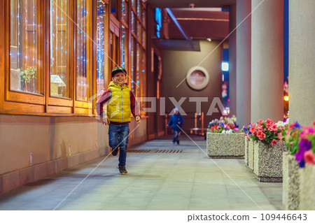 Happy little boys runs along passway with columns with flowers Happy little boys runs along passway with columns with flowers 109446643