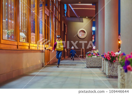 Happy little boys runs along passway with columns with flowers Happy little boys runs along passway with columns with flowers 109446644