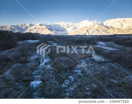 Mt. Goryu, Mt. Karamatsu and Matsukawa shining in the morning sun, Hakuba Village, Nagano Prefecture (aerial shot by drone) 109447568