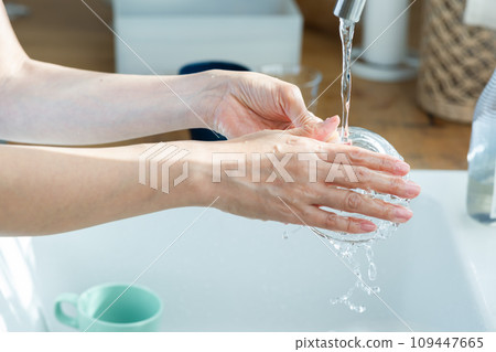Clean hands of a woman washing dishes Clean hands of a woman washing dishes 109447665