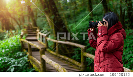 Female photographer taking nature pictures inside the rainforest 109450123
