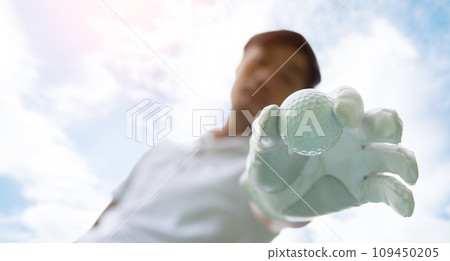 Golfer putting golf ball on tee on golf course Golfer putting golf ball on tee on golf course 109450205