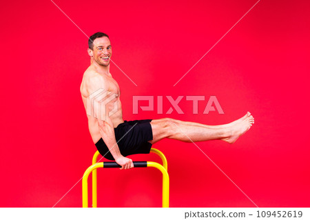 Male gymnast performing handstand on parallel bars, studio shot Male gymnast performing handstand on parallel bars, studio shot 109452619