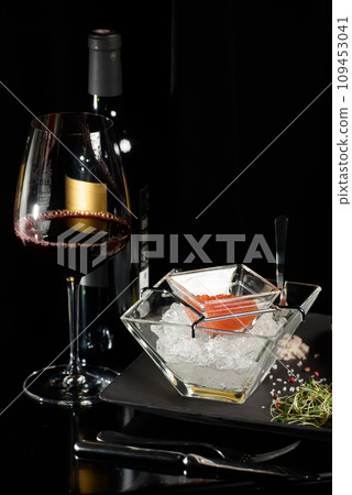 salmon fish caviar, on ice, with croutons, lemon, on a transparent dish, on a dark background salmon fish caviar, on ice, with croutons, lemon, on a transparent dish, on a dark background 109453041