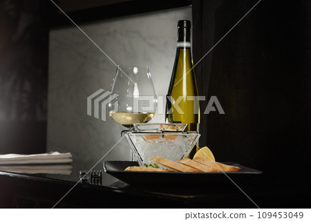 Pike fish caviar, on ice, with croutons, lemon, on a transparent dish, on a dark background 109453049
