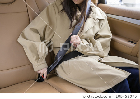 A person wearing a seatbelt in the back seat A person wearing a seatbelt in the back seat 109453079