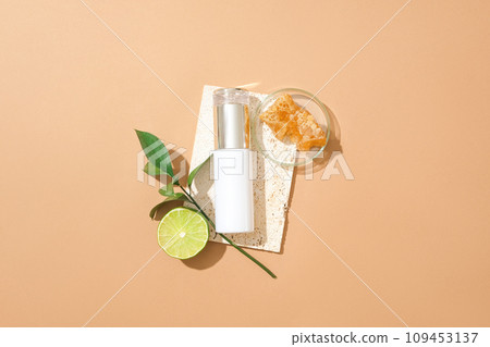 A bottle without label decorated with a lime slice, green leaves and a glass petri dish containing beeswax. Honey also helps treat other skin conditions A bottle without label decorated with a lime slice, green leaves and a glass petri dish containing beeswax. Honey also helps treat other skin conditions 109453137