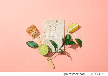 A stone podium decorated with a branch of leaves, lime slices and beeswax. Studio podium or platform product template mockup A stone podium decorated with a branch of leaves, lime slices and beeswax. Studio podium or platform product template mockup 109453150