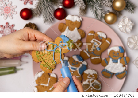 Decorating Christmas gingerbread with sugar multicolored icing. 109454705