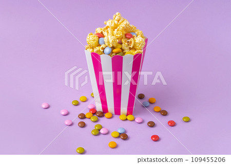 sweet popcorn with dragee on purple background 109455206
