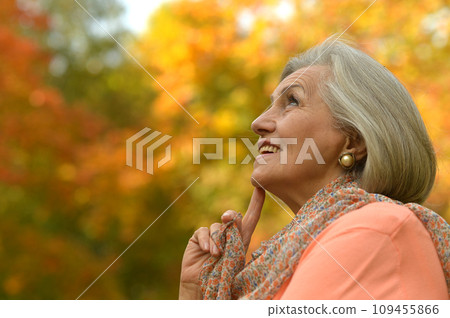Senior woman walking in the park in autumn. Senior woman walking in the park in autumn. 109455866