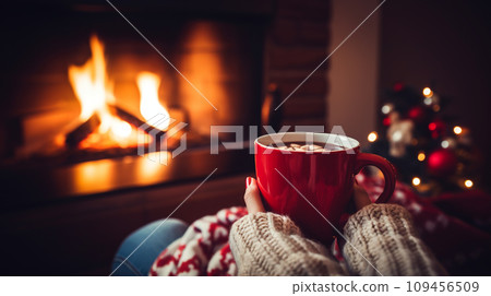 Mug of hot drink near fireplace Mug of hot drink near fireplace 109456509