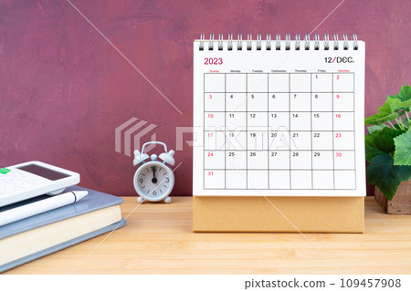 December Monthly desk calendar for 2023 year and calculator on wooden table. 109457908