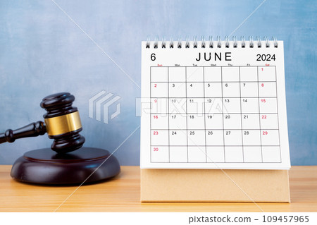 Desk calendar for June 2024 and judge's gavel on the table. 109457965