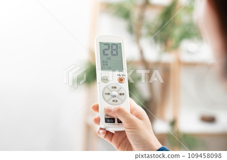一位女士用遙控器檢查空調溫度 109458098