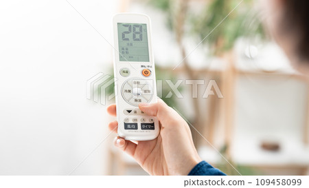 一位女士用遙控器檢查空調溫度 109458099