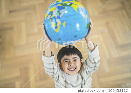 7 year old boy holding a globe beach ball 7 year old boy holding a globe beach ball 109458112