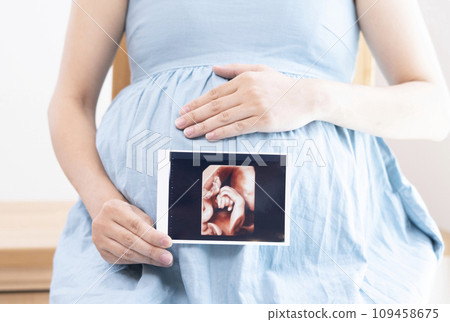 Image of a pregnant woman holding an echo photo Image of a pregnant woman holding an echo photo 109458675