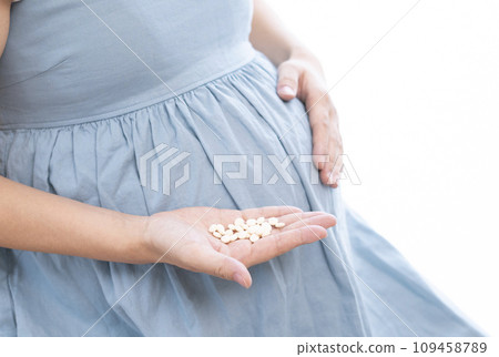 Image of a pregnant woman taking medicine Image of a pregnant woman taking medicine 109458789