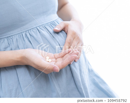 Image of a pregnant woman taking medicine Image of a pregnant woman taking medicine 109458792