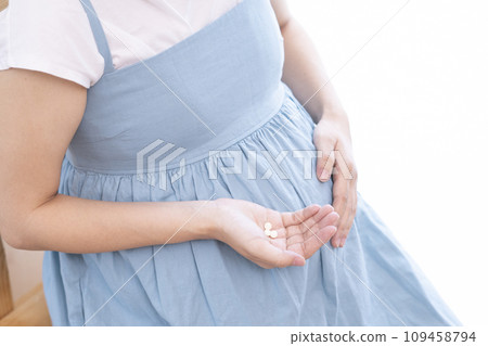 Image of a pregnant woman taking medicine Image of a pregnant woman taking medicine 109458794