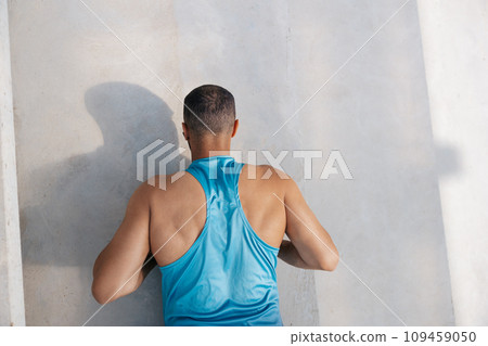 Man in blue tshirt exercising and doing push ups 109459050