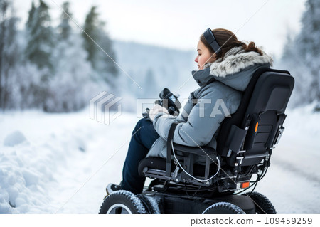 A young woman in a wheelchair in winter city street. AI generated 109459259