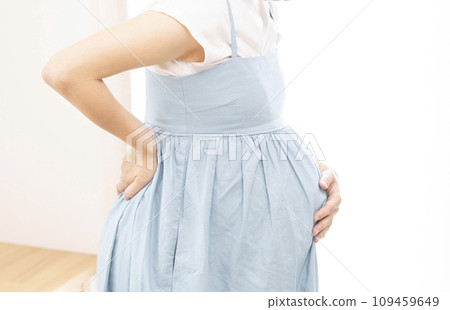 Pregnant woman putting her hands on her hips Pregnant woman putting her hands on her hips 109459649