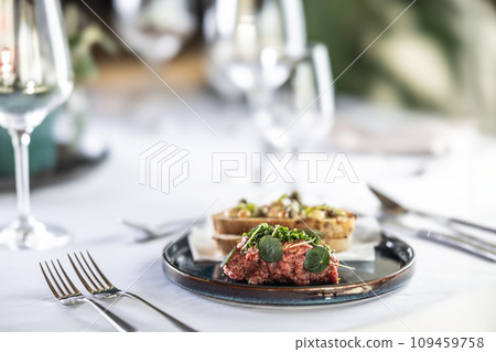 Steak Tartare with bread toasts served on a restaurant table Steak Tartare with bread toasts served on a restaurant table 109459758