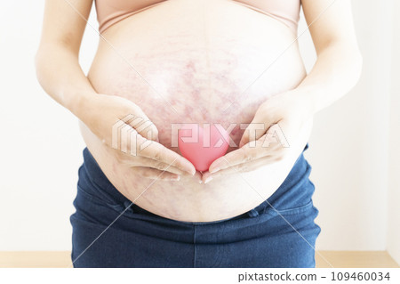 Pregnant woman putting her hand on her stomach with stretch marks and midline 109460034