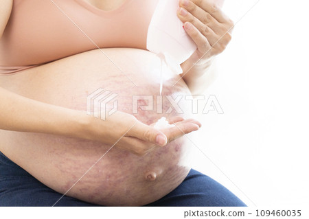 女人的手在有妊娠紋的腹部和懷孕的腹部上塗抹奶油 109460035