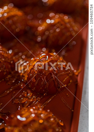 Drizzling caramelized sugar on top of silicone molds to make caramel cupcake toppers. 109460784