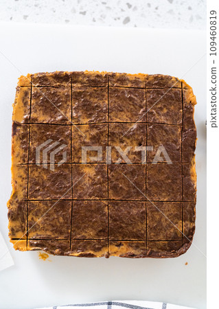 Scoring chocolate peanut butter fudge for cutting into small pieces. 109460819