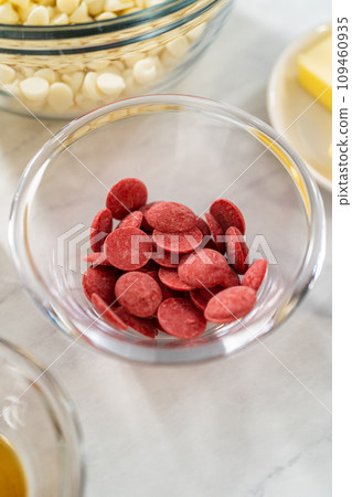 Measured ingredients in glass mixing bowls to prepare green fudge with red hearts. 109460935