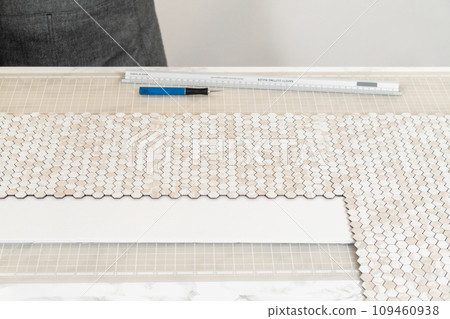 In the process of mounting peel and stick mosaic tiles onto a foam board, perfect for enhancing a food photography studio's aesthetic. In the process of mounting peel and stick mosaic tiles onto a foam board, perfect for enhancing a food photography studio's aesthetic. 109460938
