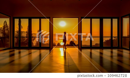 AI-generated content. the sun rising over the sea shines into the windows of the room, the silhouette of a person 109462728