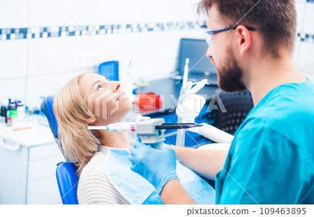 Dentist treating blond smiling girl 109463895