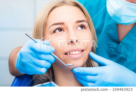 Closeup of dentist examinating blond girl with tool Closeup of dentist examinating blond girl with tool 109463923