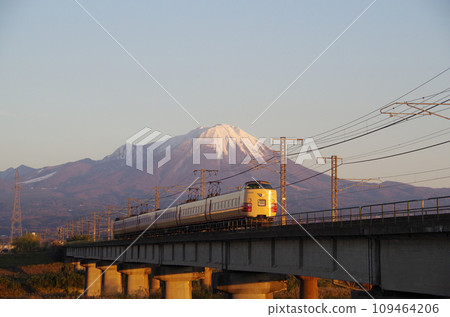 Snow-capped Mt. Oyama dyed crimson in the evening, and the departing JNR-colored 381 series Yakumo express train (following behind) Snow-capped Mt. Oyama dyed crimson in the evening, and the departing JNR-colored 381 series Yakumo express train (following behind) 109464206