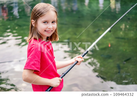 Little girl holding fishing rod on pond background 109464332