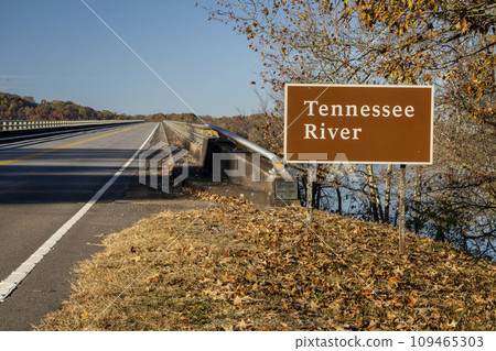 Tennessee River road sign at Natchez Trace Parkway - crossing from Tennessee to Alabama in fall scenery 109465303