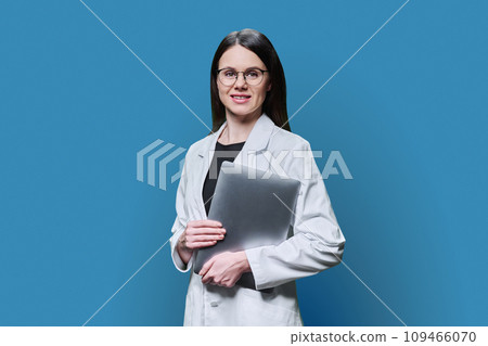 Woman medical scientist, pharmacist in white coat with laptop on blue background Woman medical scientist, pharmacist in white coat with laptop on blue background 109466070