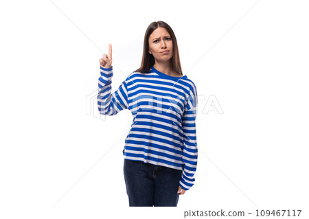 portrait of a European pretty brunette young lady in a casual striped sweater and jeans on a white 109467117